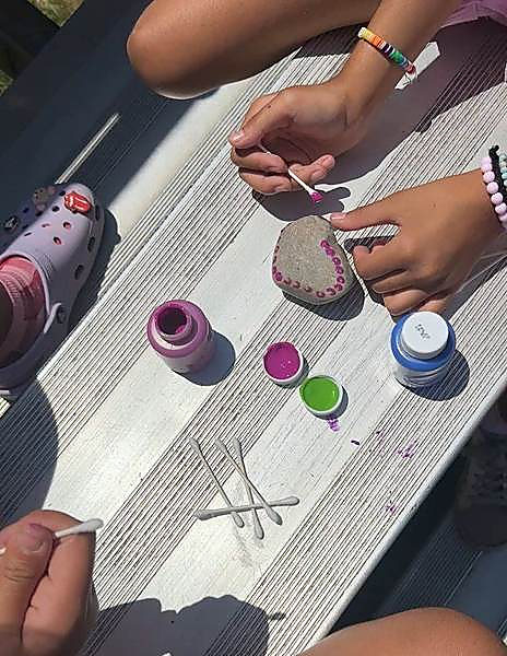 Kids painting rocks at an outdoor picnic table on a PA Day with Hexagon