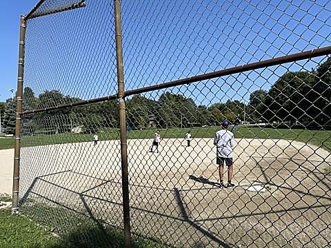 Kids playing ball on the diamond at the neighbourhood park